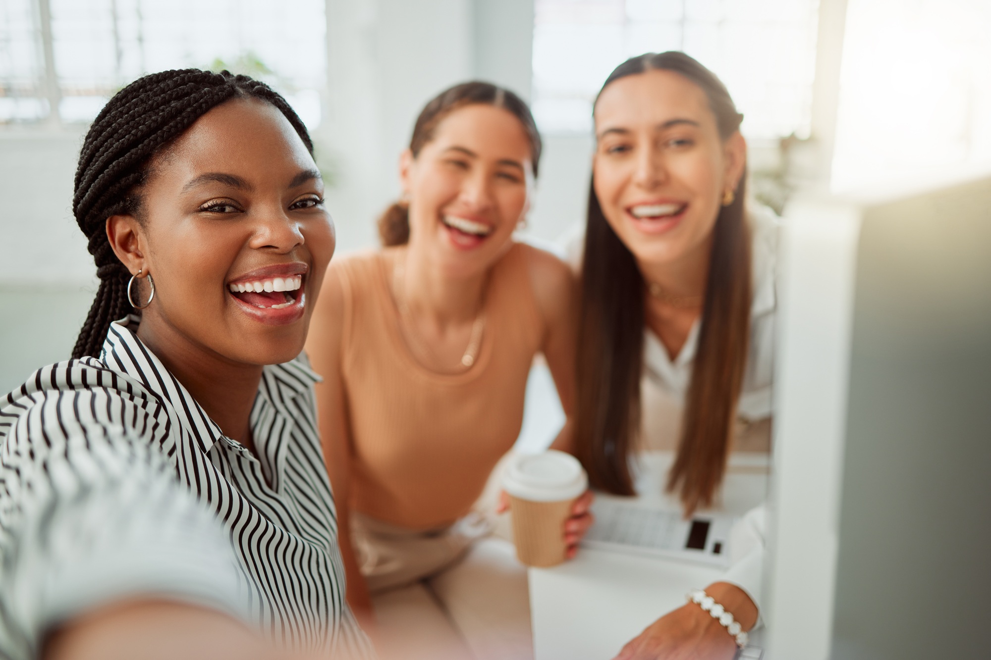 Portrait of a confident young african american business woman taking selfies with her colleagues in